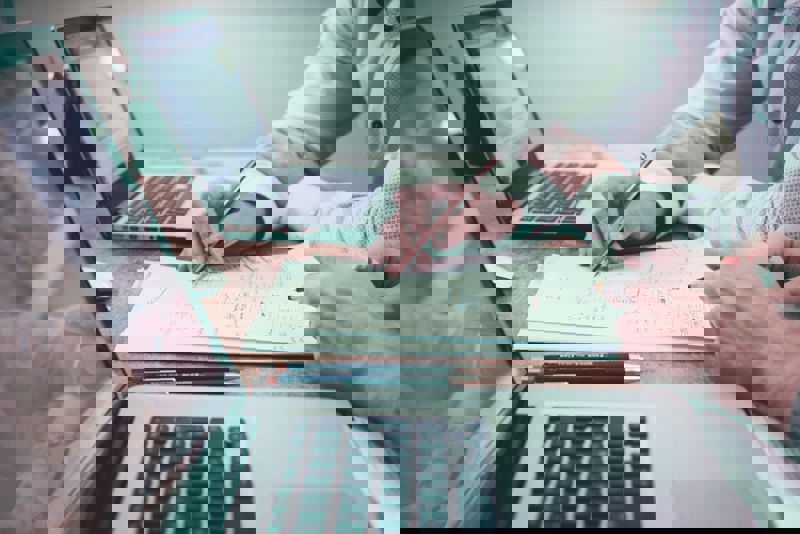twee mannen die bezig zijn met hun boekhouding op de laptop.